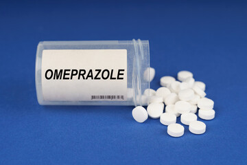 On a blue surface are pills and a dusty jar with the inscription - Omeprazole