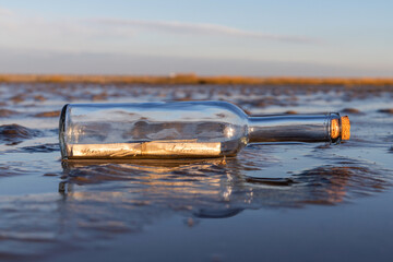 bottle post in the Wadden Sea at sunset