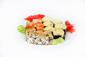 Delicious baked sushi and rolls on a white plate. Delicious breakfast of fish rice rolls and sushi on a white background. Oriental fish cuisine. Japanese cuisine.