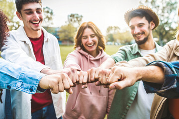 Multiracial group of young people making fist bump as symbol of unity, community and solidarity -...