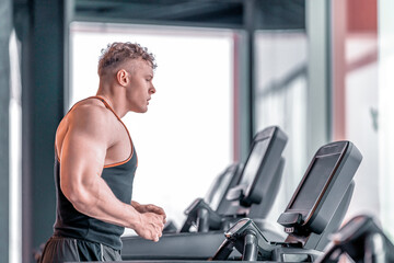 Fototapeta na wymiar young athlete runs on a treadmill in the gym