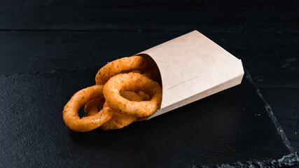 Fried onion rings in a paper box.