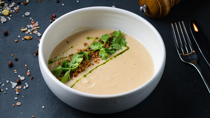 Cauliflower cream soup with fried onion, parsley, spices and green oil.