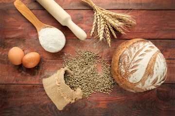 Wheat ears, sack with grain on a wooden light background. Round whole grain bread. Rolling pin,...