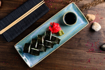Set of sushi rolls with salmon, cream cheese, avocado, wasabi, ginger and soy sauce.