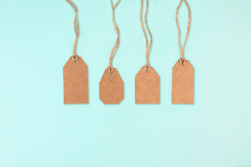 Brown kraft paper tags with jute rope on blue background. Sale discount concept. Copy space, flat...