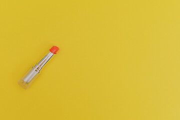 Lipstick with a bright green cap on a yellow background