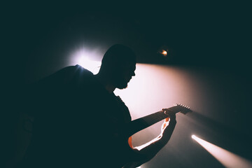 Silhouette of a person with guitar. - obrazy, fototapety, plakaty
