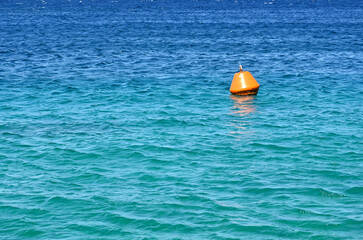 Fototapeta na wymiar Orange buoy floating on the sea as a warning to ships. No people. Copy space.