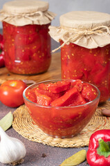 Pickled sweet peppers with tomatoes in bowl and also in two glass jars, vertical image