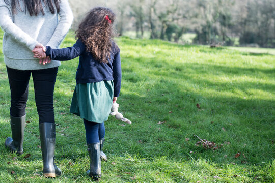 A mother and six year old daughter enjoying being out in the garden on an early Spring day.