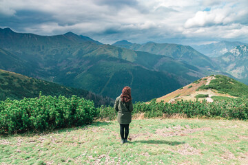 Fototapeta na wymiar Brunette girl on the background of landscape and green mountains