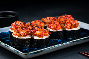Sushi rolls with salmon, cream cheese, avocado, flying fish caviar, rice and nori.