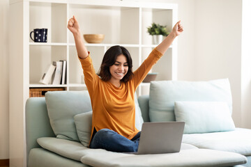 Good News. Happy Young Arab Woman Celebrating Success With Laptop At Home