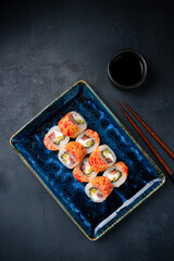 Japanese cuisine set of sushi rolls with tuna, cream cheese, mango, flying fish caviar and soy sauce.