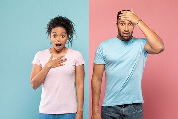 Shocked black couple opening mouths in shock, woman putting hand on heart, man touching head, pink and blue background