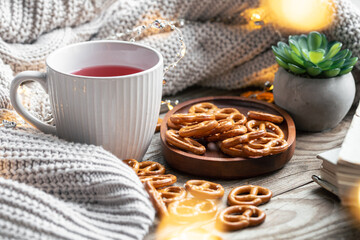 Cozy home composition with a cup of tea and pretzels.