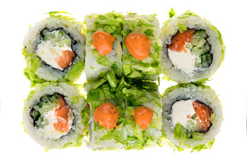 Japanese sushi rolls with salmon, cream cheese, cucumber, lettuce, rice, nori and sauce isolated on white.