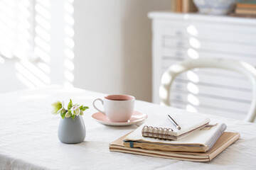 Home desk with notepad and coffee cup.