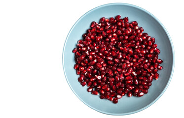 Grains of tasty bright red peeled pomegranate lie in a plate on a white isolated background. Top view. Close-up.