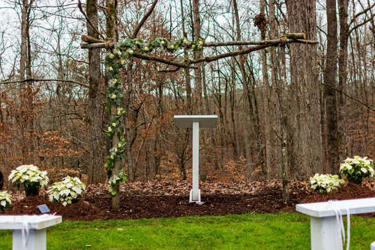 A white, wooden pulpit stands at the alter for an outdoor wedding.