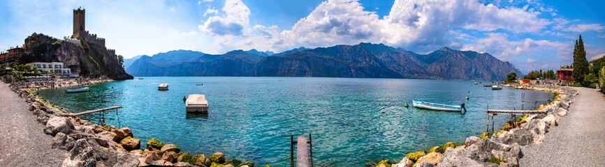 Amazing italian lake scenery - panorama of beautiful Lago di Garda. panoramic view of Malcesine castle and beach - obrazy, fototapety, plakaty