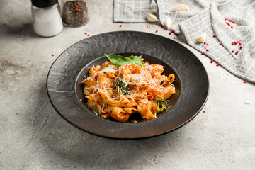 Fettuccine with shrimps with tomato sauce and parmesan on grey table