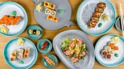 Philadelphia roll with salmon, sushi,tempura roll,shrimps,salad with salmon top view on wooden table