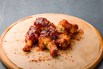 chicken wings in barbecue sauce on grey table