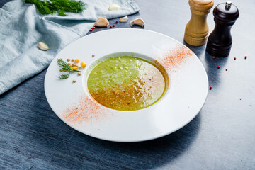 Cream of broccoli soup with peanut on blue table