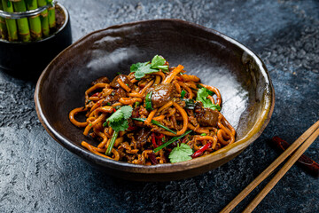 egg noodles with beef on dark stone table, Chinese cuisine - 554980214