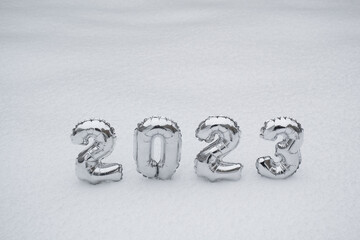 Silver numbers 2023 on a background of white snow in winter. Copy space. Concept of the New Year