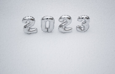 Silver numbers 2023 on a background of white snow in winter. Copy space. Concept of the New Year