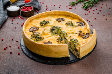 Quiche with chicken and mushrooms on brown table