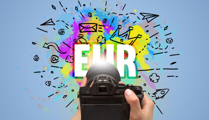 Close-up of a hand holding digital camera with abstract drawing