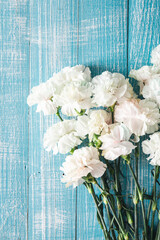 Blue wooden background with white flowers, flat lay.