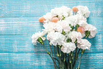 Blue wooden background with white flowers, flat lay.