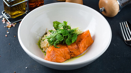 Salmon fillet with creamy ptitim, parmesan cheese, parsley and lettuce.