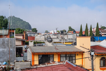 Fototapeta premium Beautiful sunny day in mountain city in Mexico. The famous tiled roofs of the city.