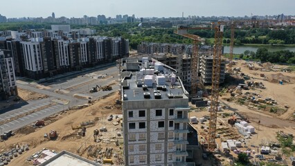 Minsk, Belarus - 01.08.2022: Construction of a multi-storey residential building in the center of the city of Minsk. The erected frame of the house. High cranes are building a high-rise building.