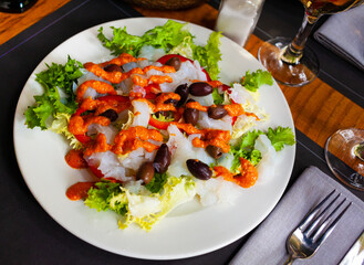 Traditional catalan dish Xatonada, salad with crumbled cod, olives, bell pepper and popular sauce...