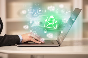 Hands working on laptop with digital icons