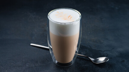 Coffee latte with milk in a transparent glass cup.