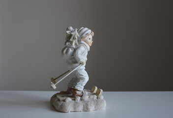 Fototapeta na wymiar Skiing boy figurine. Retro statuette, vintage, antique objects. Winter Holidays, Christmas concept