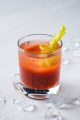 Bloody Mary cocktail with red hot chili peppers, celery stick, tomatoes and copyspace