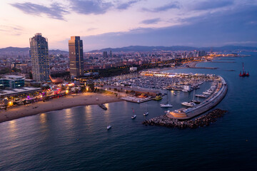 Naklejka premium Picturesque evening aerial view of coastal area of Barcelona overlooking Olympic Harbor marina with moored pleasure yachts and modern architecture of waterfront in summer, Spain..