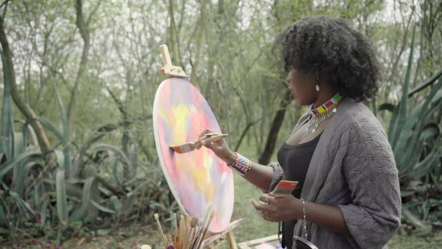 young woman painting in nature