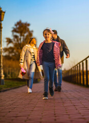 A happy three-member family walks and enjoys a beautiful winter day.