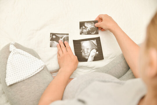 Pregnant woman holding 4D ultrasound image. Expectation of a child