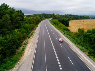 Aerial view asphalt road and green forest, Forest road going through forest with car adventure view from above, Ecosystem and ecology healthy environment concepts and background.